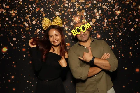 Two guests posing with glasses and a BOOM prop at a corporate event at The William Inglis Hotel