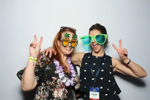 Two guests wearing oversized glasses and making peace signs at a corporate event at Hotel Steyne Manly