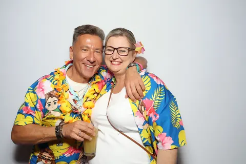 Two smiling guests in colourful floral shirts at a corporate event at Hotel Steyne Manly