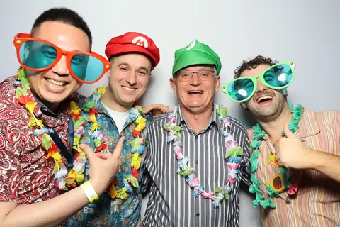 Four guests wearing colourful hats and oversized glasses at a corporate event at Hotel Steyne Manly