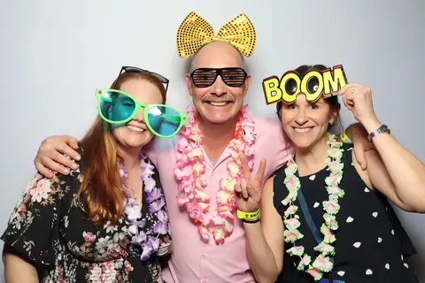 Three guests with colourful glasses and a BOOM prop at a corporate event at Hotel Steyne Manly