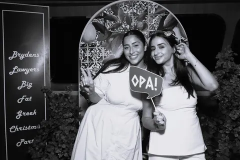 Black and white portrait of two guests with an OPA prop at a corporate event with Prestige Harbour Cruises