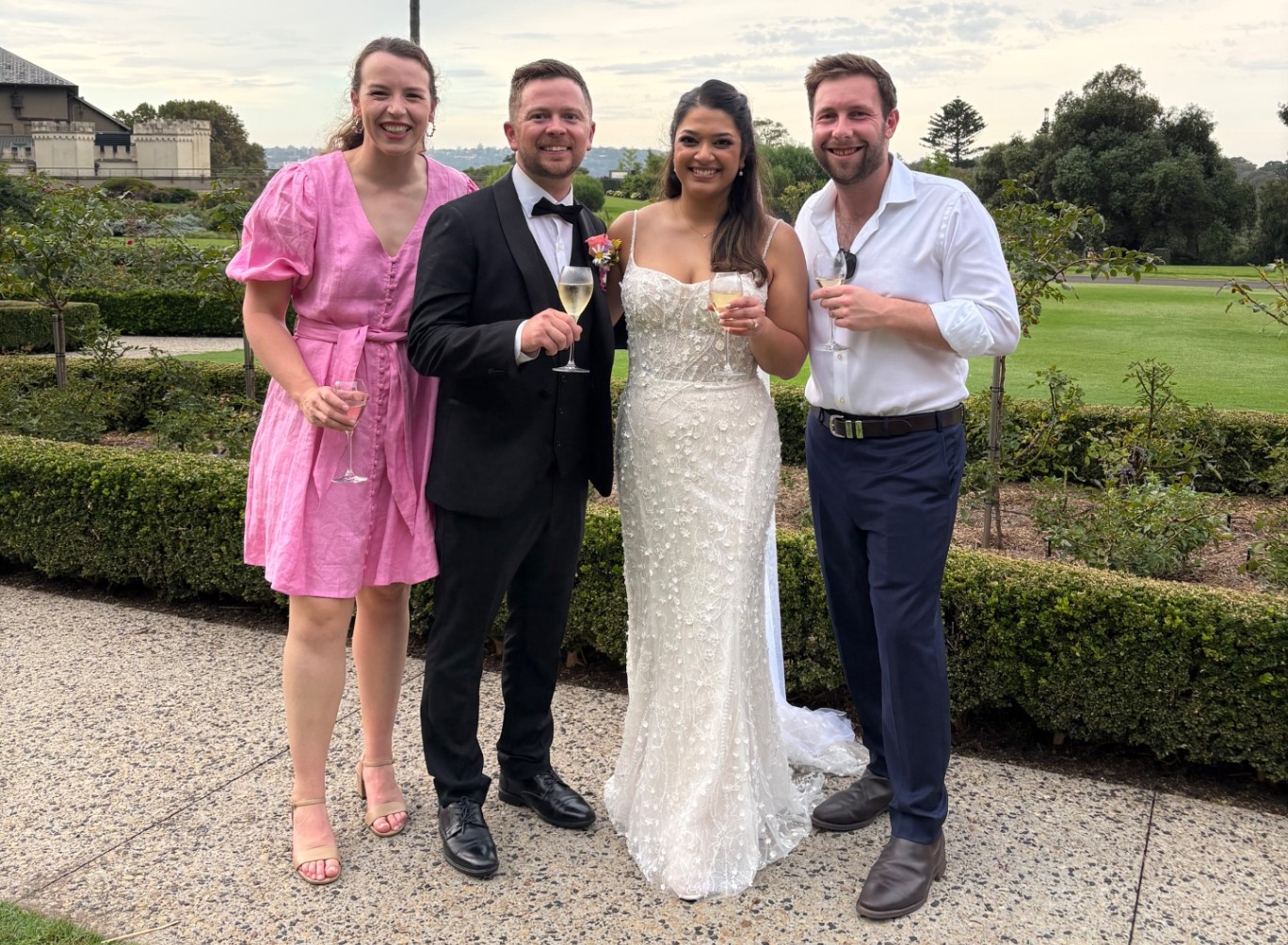 Bride and groom celebrating with friends during an outdoor wedding moment