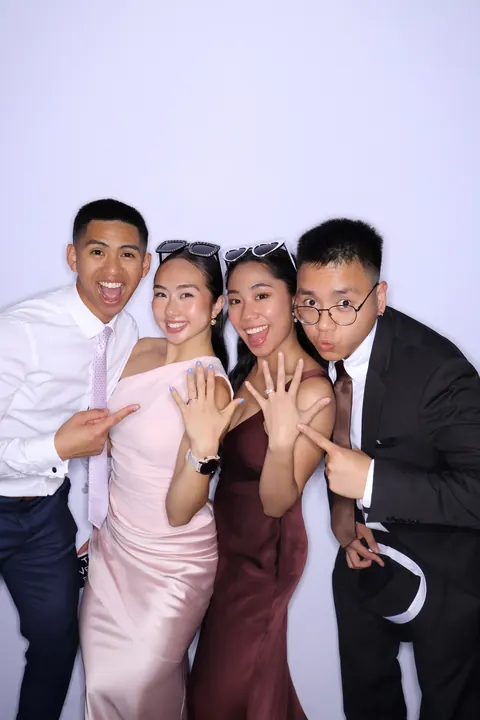 Four guests posing together for a Gold Booth portrait