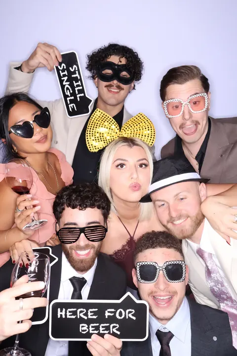 Guests wearing novelty glasses and holding playful photo booth props