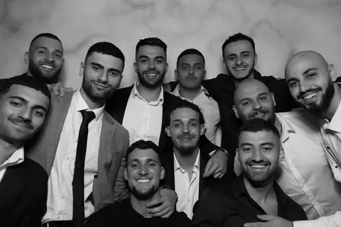 Guests posing together for a black and white Open Air photo booth portrait
