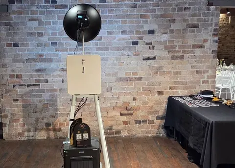 Open Air Photo Booth against a brick-patterned backdrop