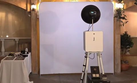 Open Air Photo Booth with a white backdrop at an indoor event