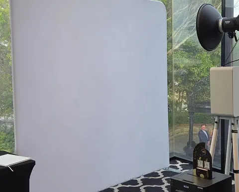 Open Air Photo Booth with a white backdrop beside venue windows