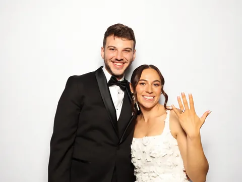 Bride showing her ring while standing beside the groom