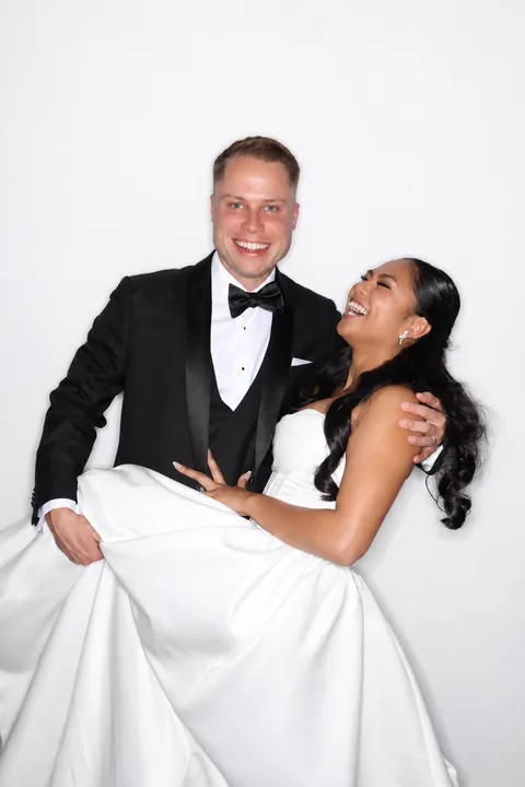 Groom carrying the bride as they laugh together